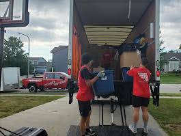 Budget Movers crew loading items into the truck at dusk