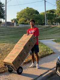 Budget Movers crew member moving stacked boxes with a dolly