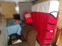 Interior of a Budget Movers truck packed with blanket-wrapped furniture