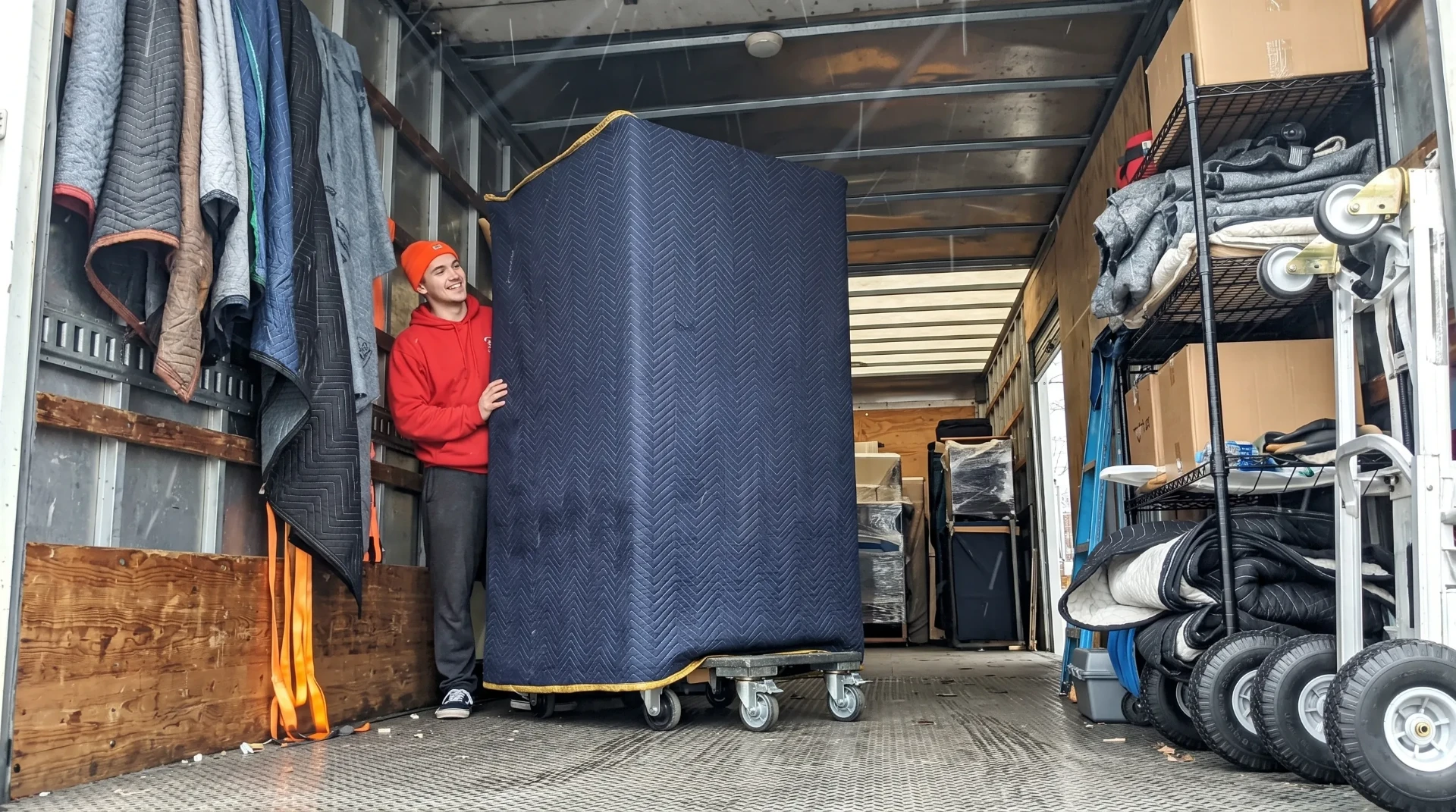 Budget Movers team member loading wrapped furniture into moving truck