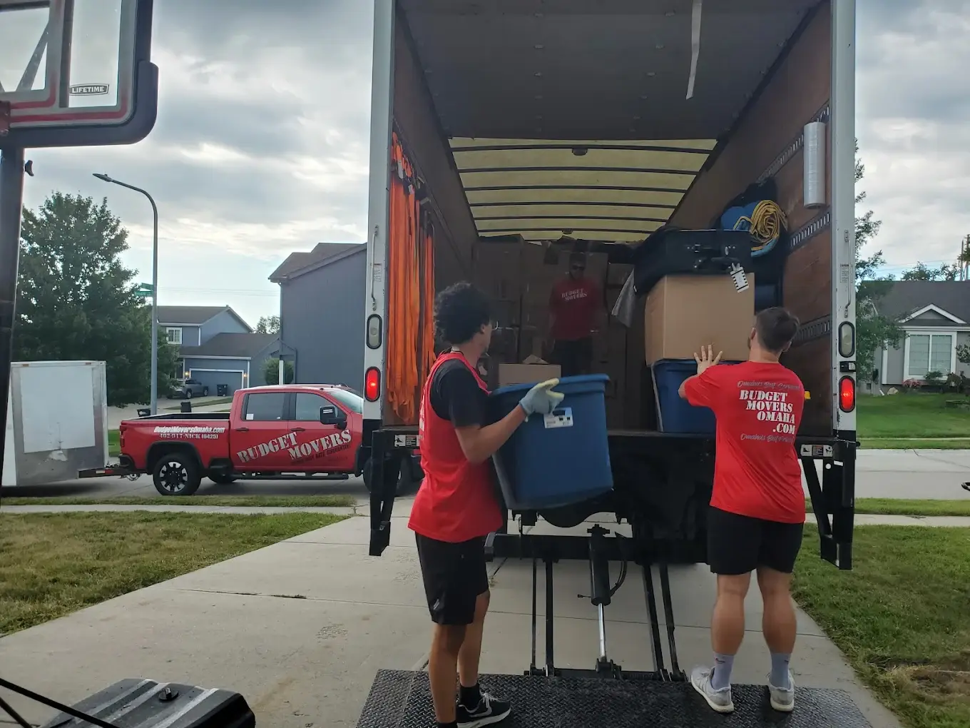 Budget Movers crew loading totes into a box truck at a residential move