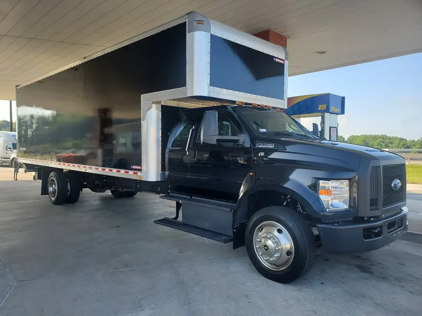 Budget Movers black box truck refueling at a station