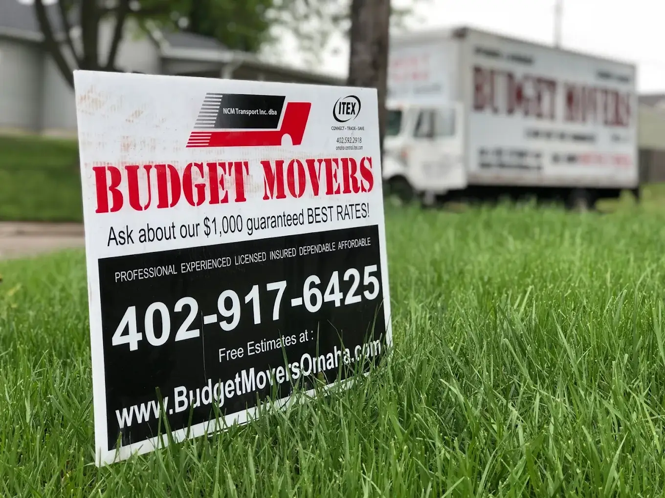 Budget Movers $1,000 Best Rates yard sign with truck in background